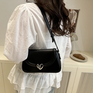 French style black underarm bag with a silver heart lock shown on model with white shirt