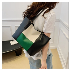 Close-up of color-block tote bag with adjustable shoulder strap on a female model