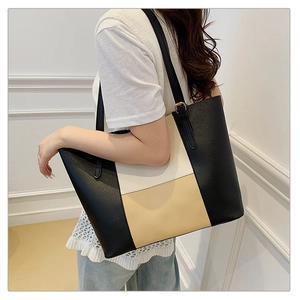 Detail of a large tri-color patchwork tote bag with leather texture and thin shoulder strap