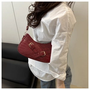 Red crocodile pattern leather underarm bag with gold buckles worn on model's shoulder