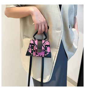 Close-up of pink snakeskin mini handbag with gold studs and black leather handles