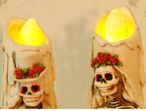 Detail of LED skull candles featuring a groom in top hat and bride with red roses