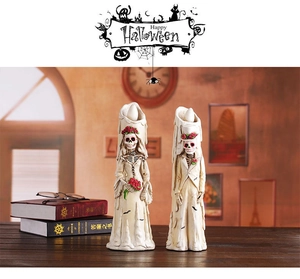 Close-up of skeleton bride and groom LED candles with vintage Halloween decorations