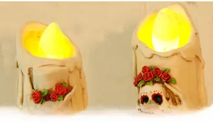 Detail of LED skull candle lamp with red roses and melting wax texture for Halloween