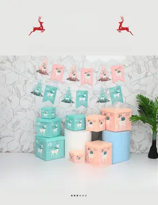 Scatole regalo di Natale rosa e blu pastello con stampe di renne e festoni decorativi