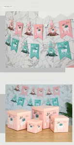 Dettaglio delle scatole regalo di Natale rosa e blu con motivi di renne e alberi