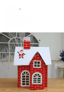 Detail of DIY Christmas snow house featuring red brick walls and snow-covered roof decor