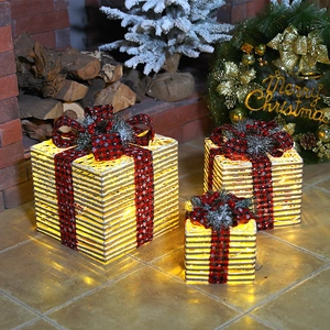Three-piece glowing Christmas gift boxes with bows and pinecones for festive decor