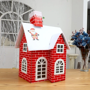 Christmas gift box in red brick house shape with snowy roof and Santa Claus decoration