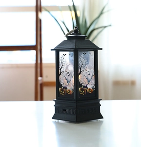 Close-up of Halloween lantern featuring ghost and pumpkin motifs with a metal ring