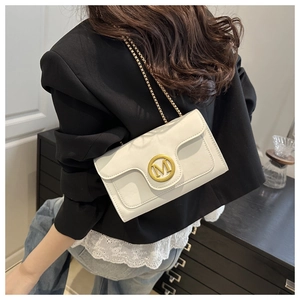 Detail of white PU leather crossbody bag featuring a decorative golden M-shaped metal buckle
