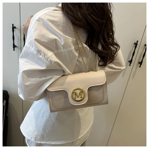 Detailed view of cream PU leather crossbody bag with gold M logo and chain strap