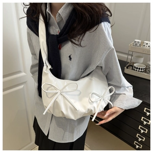 Detail shot of white crossbody cloud bag with bows and soft pleated faux leather texture