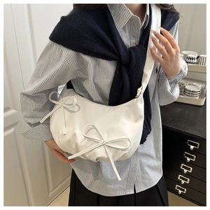 Détail du sac demi-lune blanc avec nœuds en relief et bandoulière large confortable