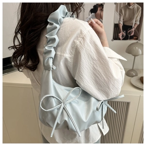 Close-up of light blue large capacity shoulder bag with a ribbon bow and pleated strap