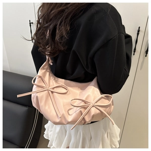 Pink ribbon bow shoulder bag with pleated satin texture shown on model for sizing