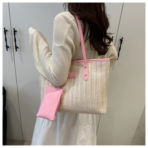 Detailed view of woven tote bag with pink leather handles and matching inner pouch