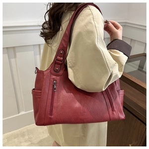 Detail view of large dark red tote bag featuring lychee texture and metal zippers