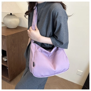 Detail of light purple crescent shoulder bag showing nylon texture and minimalist design