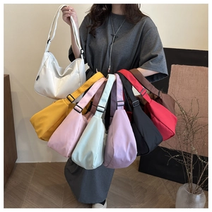 Various colors of nylon crescent crossbody bags featuring adjustable black shoulder straps