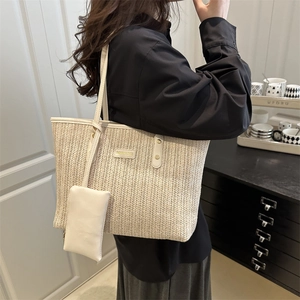 Minimalist woven straw tote bag with leather trim and matching small pouch