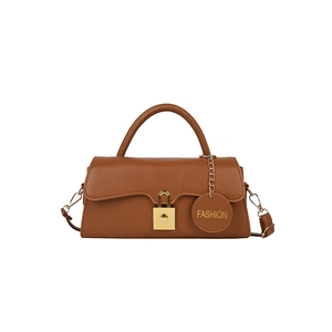 Détail du sac bandoulière marron caramel avec serrure dorée et étiquette de mode