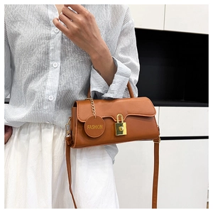 Detail of caramel leather shoulder bag with gold clasp and fashion logo tag
