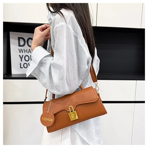 Detail of caramel faux leather shoulder bag with gold padlock clasp and fashion tag