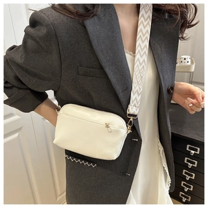 Detail of white rectangle crossbody bag with wide geometric woven shoulder strap