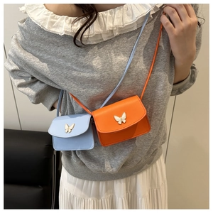 Detailed view of mini square crossbody bags with 3D butterfly decor in blue and orange