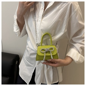 Mannequin portant un mini sac bandoulière vert citron avec un nœud en strass