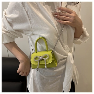 Vue détaillée du mini sac à bandoulière vert néon avec boucle nœud diamantée