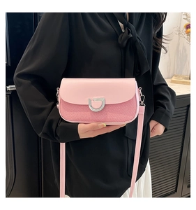 Detail of pink crossbody bag with silver D-buckle and striped fabric texture contrast