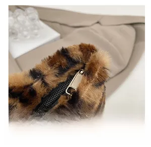 Macro shot of smooth metal zipper and thick leopard print plush texture on tote bag