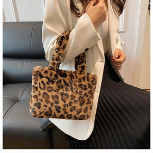 Detailed texture of leopard print plush tote bag held by a model in a white blazer