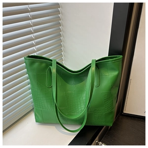 Detail view of the green crocodile pattern stitching and smooth texture on the PU tote bag