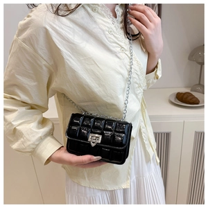 Quilted black patent leather crossbody bag with silver chain strap and metal turn-lock