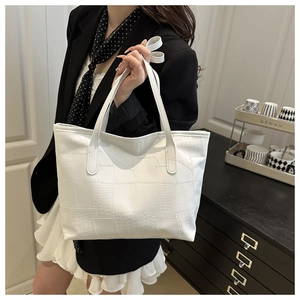 Detail showing white PU leather tote with geometric faux crocodile texture panels