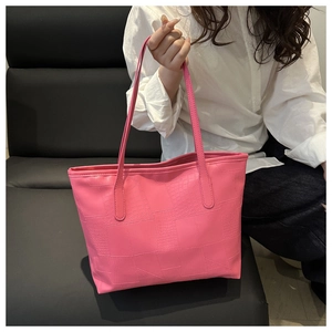 Detail of pink large capacity tote bag featuring crocodile and stone pattern textures