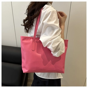 Detail of pink faux crocodile leather tote bag with geometric stitching on shoulder