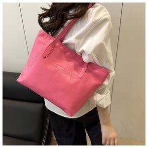 Detail of hot pink tote bag featuring premium crocodile embossed texture and sturdy handles