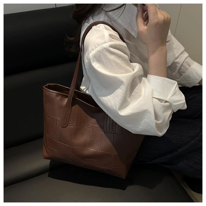 Detail view of large brown PU tote bag with elegant crocodile texture for daily commute