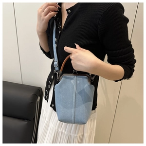 Light blue denim bucket bag shown on a model with vintage metal clasp and top handle
