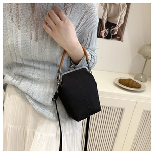 Detail of vintage silver metal clasp on black canvas bucket bag with leather handle