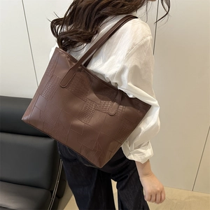 Deep brown tote bag with crocodile and lizard pattern leather in a casual home setting