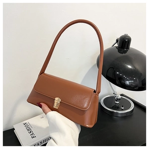 Detail shot of the caramel brown faux leather baguette bag with golden metal flip lock clasp