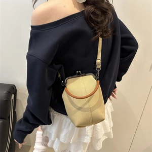 Canvas clasp crossbody phone bag with leather-wrapped handle on a female model