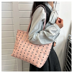 Detail of pink tote bag with bear print, showing metal rivets and large capacity shoulder strap