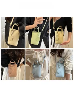 Mini borsa a secchiello trama litchi in colori pastello con ciondolo a cane e tracolla