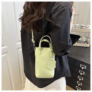 Détail du mini sac vert menthe avec bandoulière réglable et breloque chien sur mannequin